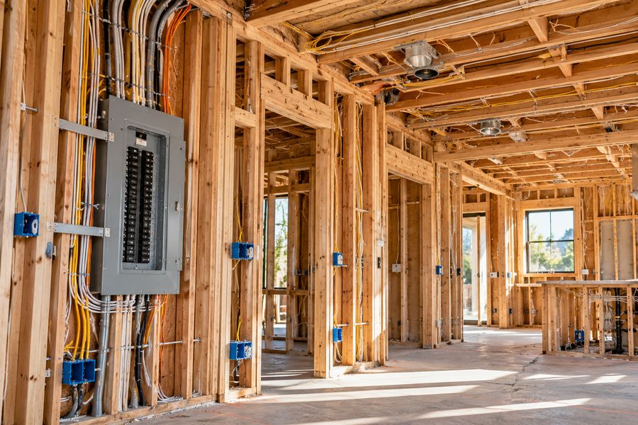 Home under construction with framing, wiring, and a main electrical panel
