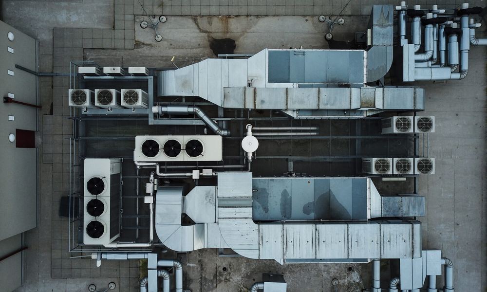 Aerial view of rooftop chillers, air handlers, ductwork, and piping